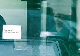 Bolsonaro es visto a través de una puerta acristalada de la sede de la Policía Federal de Brasilia, donde se encuentra recluido desde el sábado.