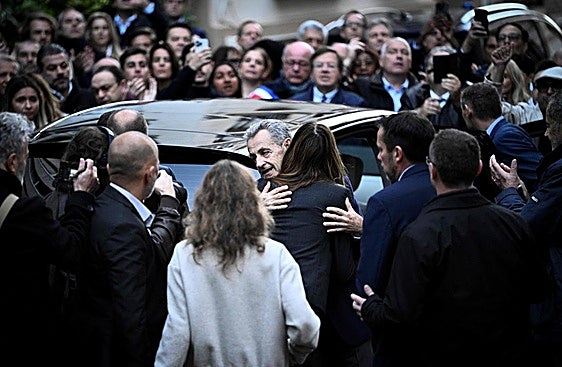 El expresidente Nicolas Sarkozy abraza a su mujer, Carla Bruni, antes de presentarse en la prisión de La Santé.