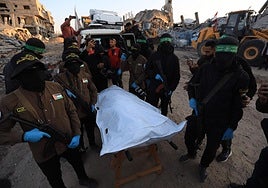 Miembros de Hamás trasladan los restos de un rehén israelí.