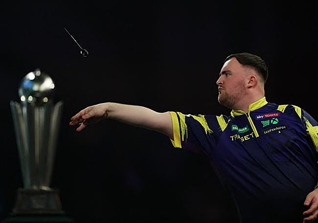 Luke Littler lanza un dardo.