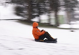 Una persona se desliza en un trineo en una urbanización en Alpedrete, Madrid.
