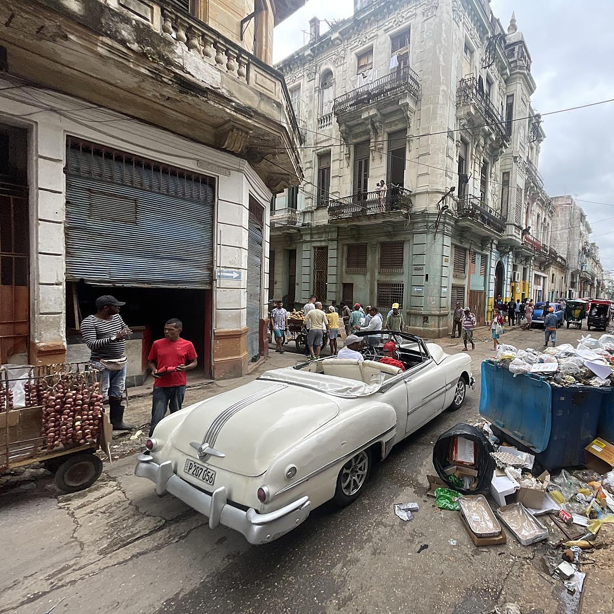 Un automóvil para turistas circula sin clientes por el centro de La Habana, lleno de basura.