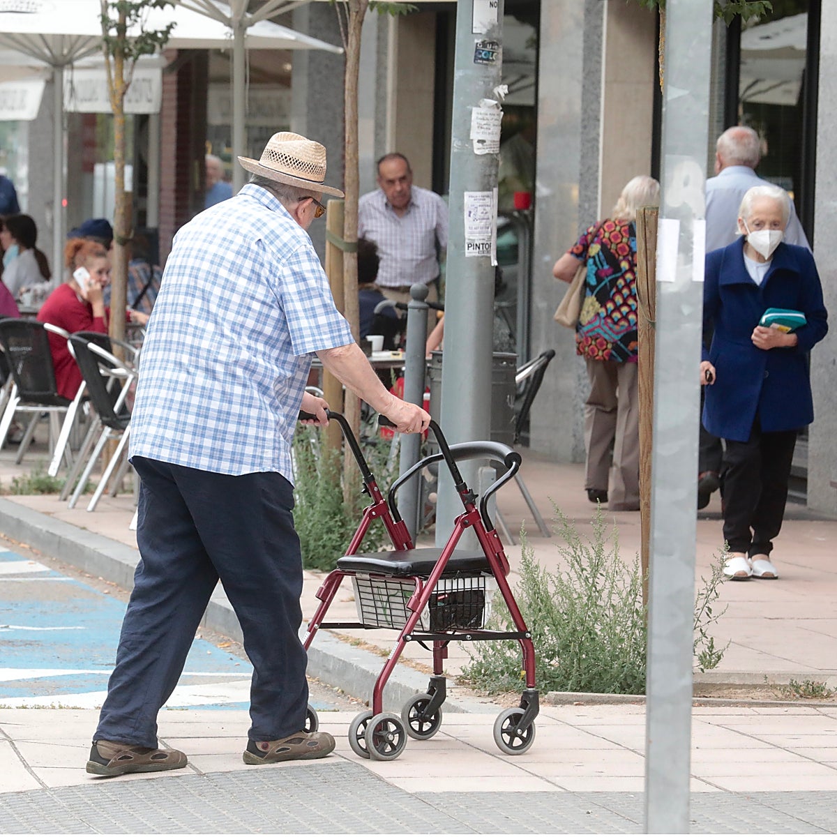 Un hombre se desplaza por la calle con la ayuda de un andador.