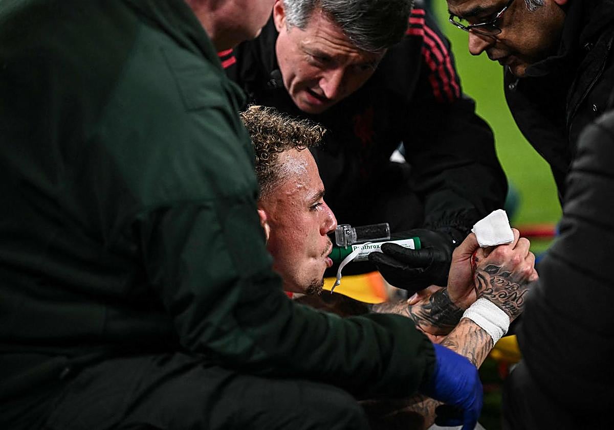 Ana resim - Yukarıdaki resimde Noa Lang olaydan sonra oksijen alıyor. Aşağıda, solda, futbolcu bir sedye üzerinde taşınıyor. Sağda, Liverpool personeli kesintinin meydana geldiği çitleri inceliyor.