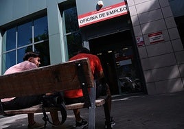 Dos jóvenes frente a una oficina de empleo.