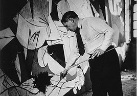 Pablo Picasso, en su taller, da los últimos retoques al Guernica'.