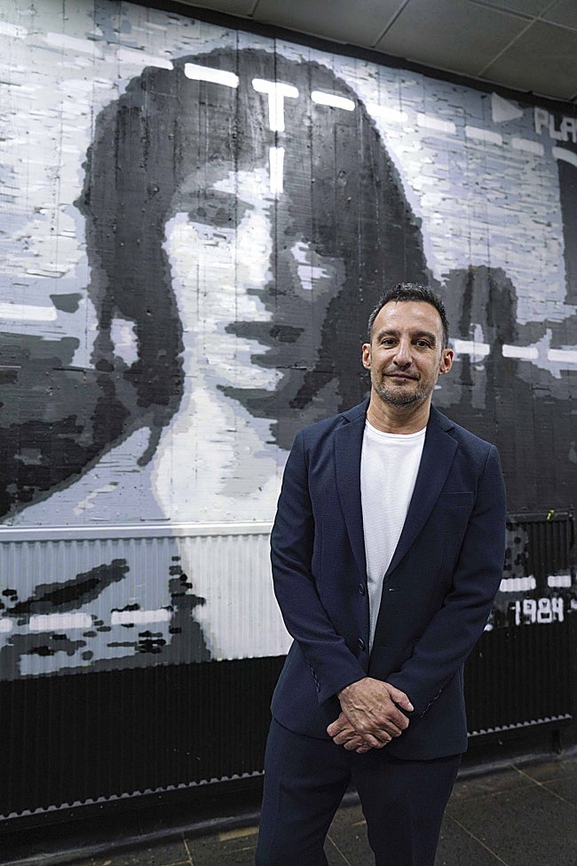 Alejandro Amenábar, delante de un mural con el cartel de su película.