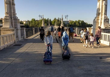 Un grupo de padres y sus hijos de camino al colegio.