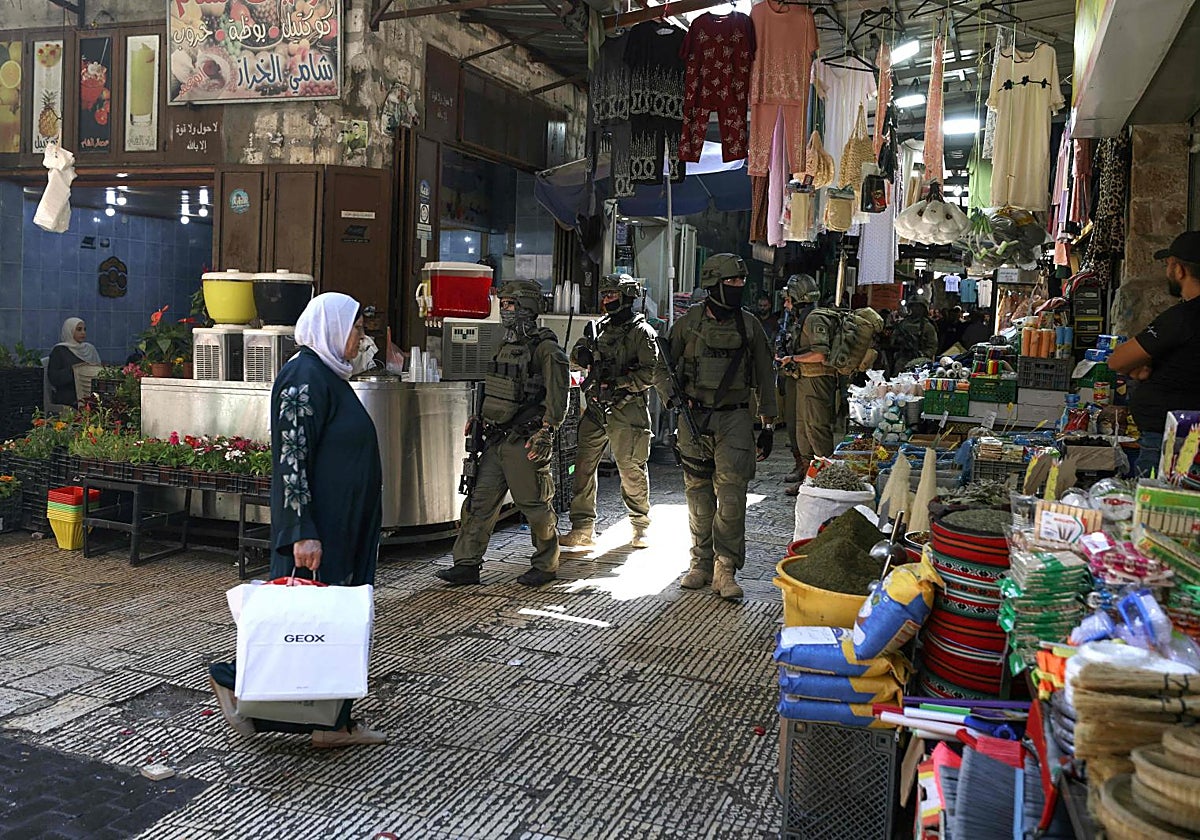 Una patrulla israelí en un mercado palestino.