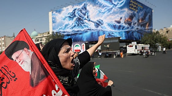 Una mujer iraní se manifiesta en Teherán con una imagen del fallecido ayatolá Ali Jamenei.
