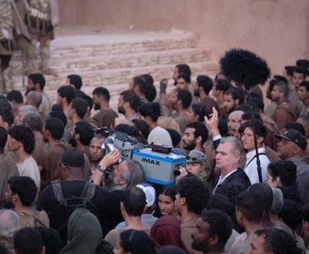 Imagen secundaria 1 - Arriba, un fotograma de la batalla de Troya; debajo, Christopher Nolan y Hoyte Van Hoytema, con la cámara IMAX, entre los extras, y Tom Holland como Telémaco.