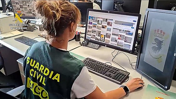 Agente de la guardia civil revisando material fotográfico incautado.