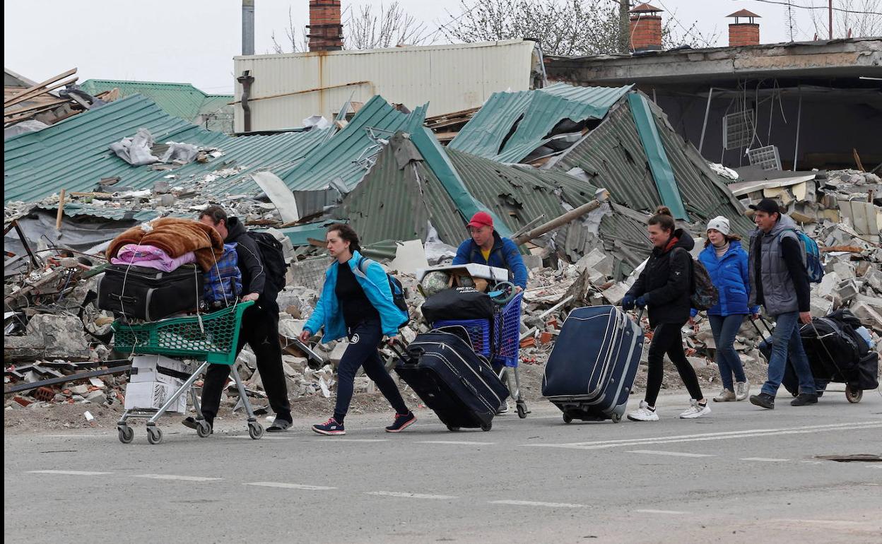 Civiles atrapados en Mariúpol arrastran sus pertenencias para huir de los bombardeos que han devastado esta ciudad portuaria.