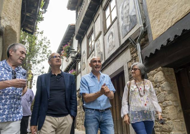 Florencio Maíllo, con el presidente de la Diputación, en una calle de la localidad repleta de retratos.