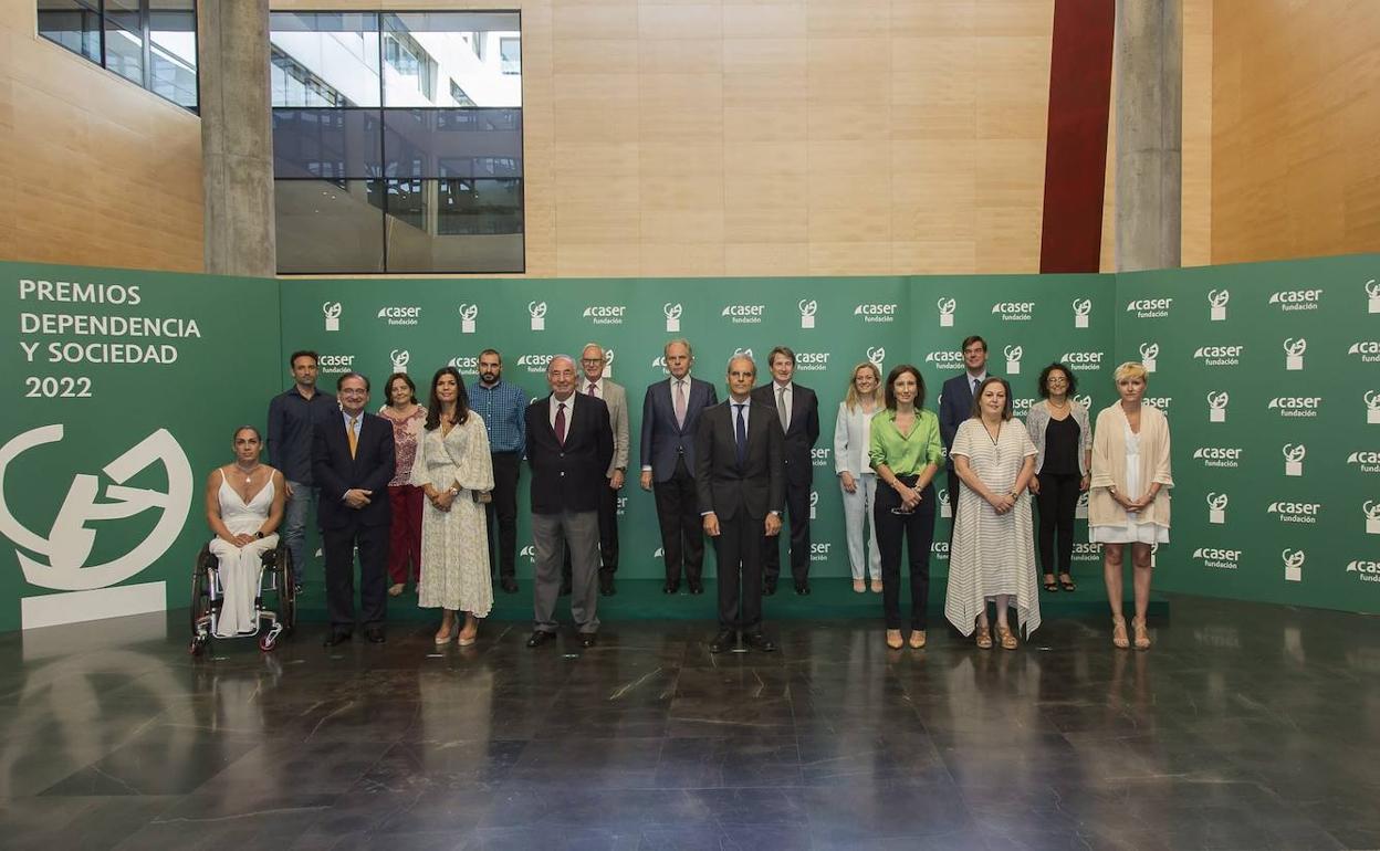 Carmen Gimenez, mención especial; Ramón Rebollo y Raquel de los Santos, representantes de NIPACE; Amado Franco, presidente de la Fundación Caser; Luis Martinez, Viceconsejero de Familia, Juventud y Política Social de la Comunidad de Madrid, y Susana Delgado, Prado Paloma y Lorena Gutiérrez, representantes de Caser Residencial; y en la segunda fila: María Belén Ruiz, junto a dos representantes de la Universidad Carlos II; José María Paagman, vicepresidente de la Fundación Caser; Ignacio Eyrés, director general de Caser; Juan Sitges, director de la Fundación Caser, y Laura López, Pedro Maqueda y Raquel Rodríguez, representantes de Mutua de Propietarios. 