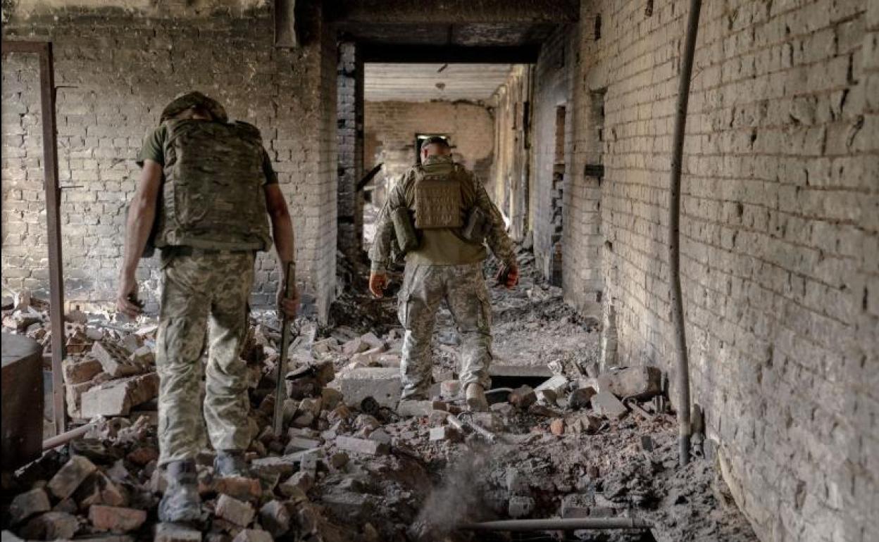 Soldados ucranianos caminan a través de un edificio destruido en Járkov. 