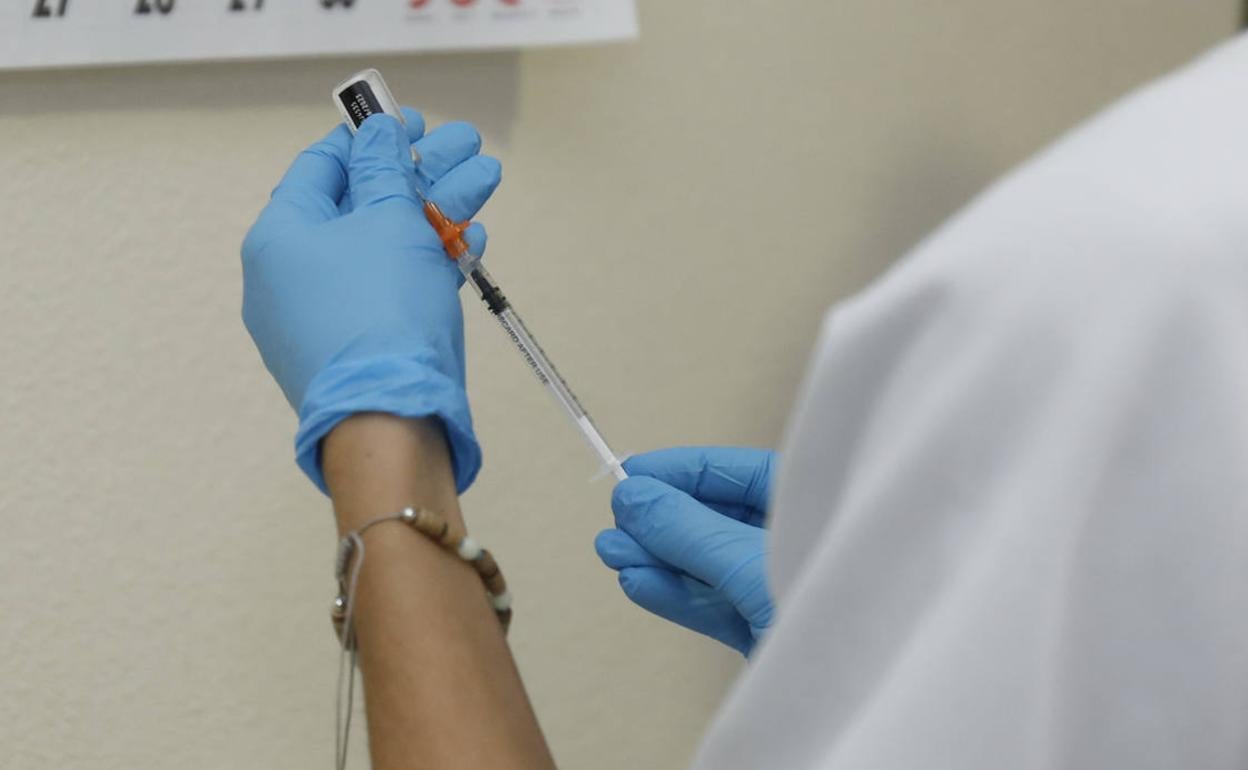 IUna enfermera prepara la vacuna del covid para inocularla. 