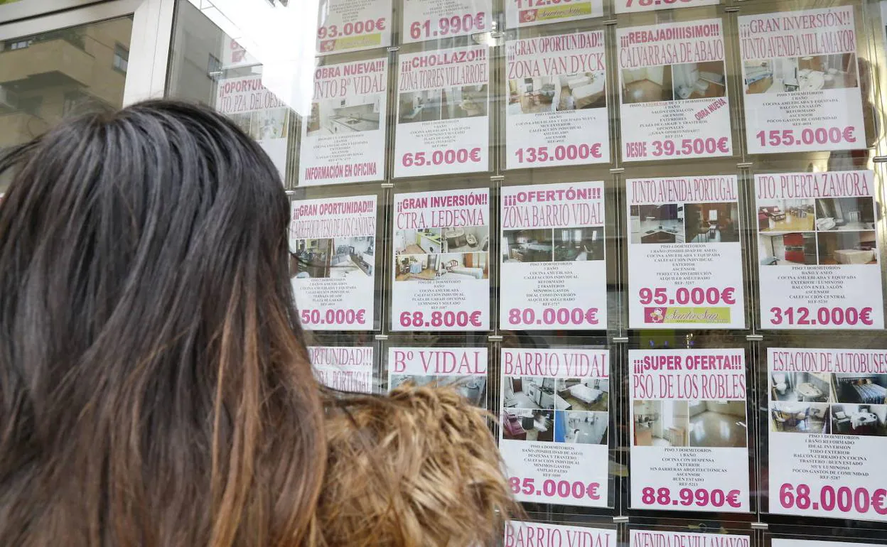 Una mujer observa anuncios de pisos en una inmobiliaria de Salamanca.
