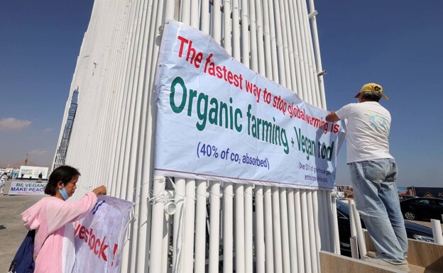 Activistas veganos despliegan una pancarta en la COP27.