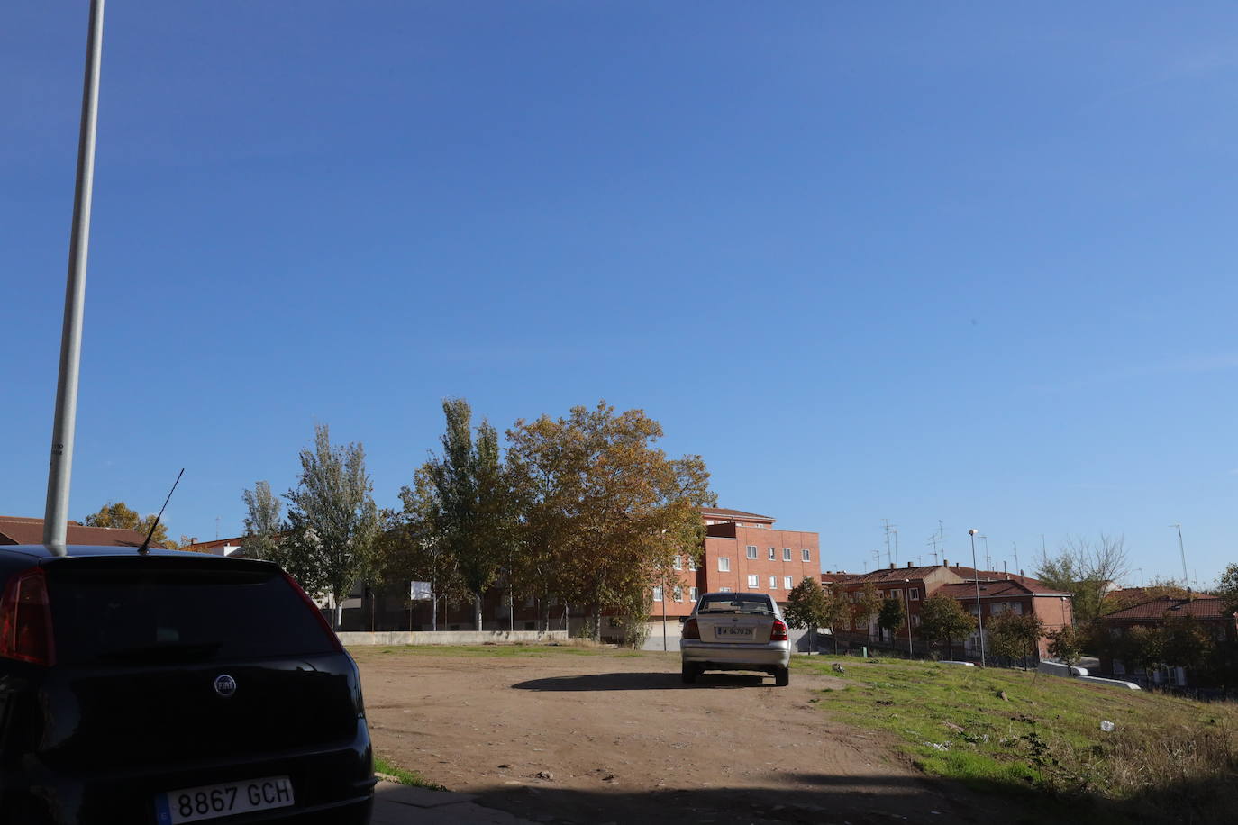 Coches aparcados en un solar.