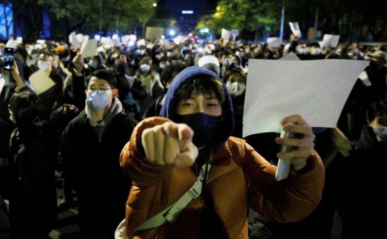 Manifestantes sostienen hojas en blanco en protesta por las restricciones del covid, en Beijing, China. 