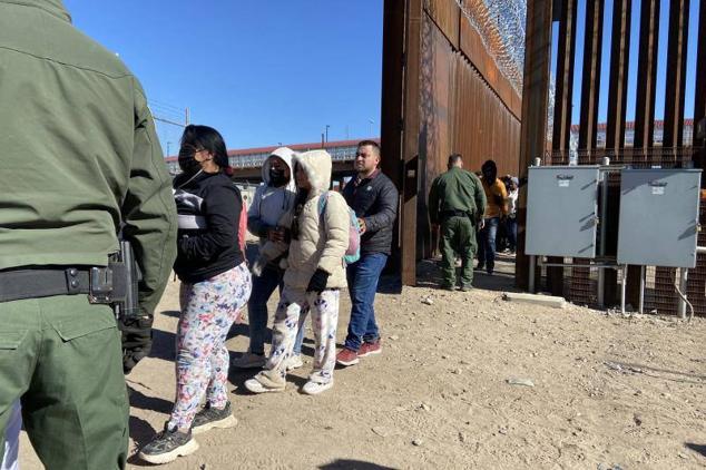 Migrantes que piden asilo se entregan a la Patrulla Fronteriza estadounidense este jueves, en la valla fronteriza de El Paso, Texas (EE UU).