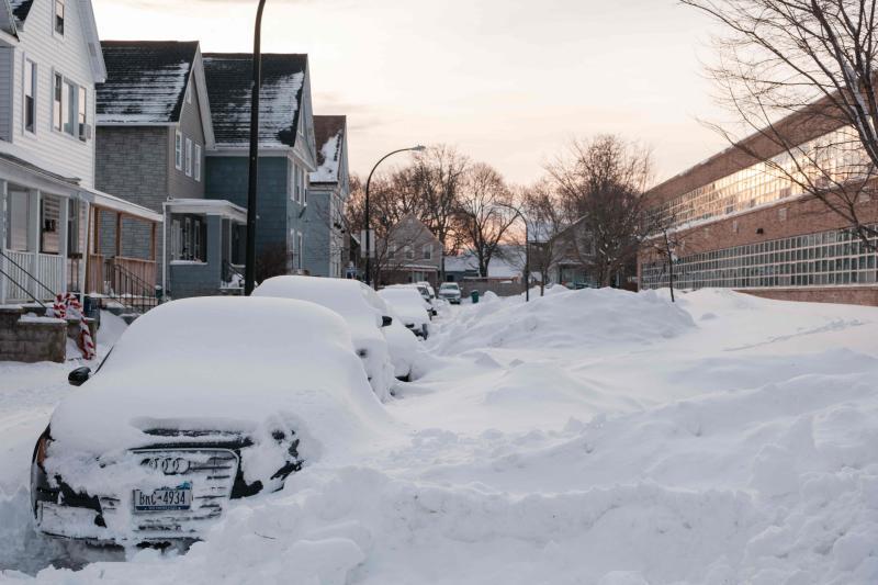 Varios vehículos permanecen bajo la nieve en una avenida