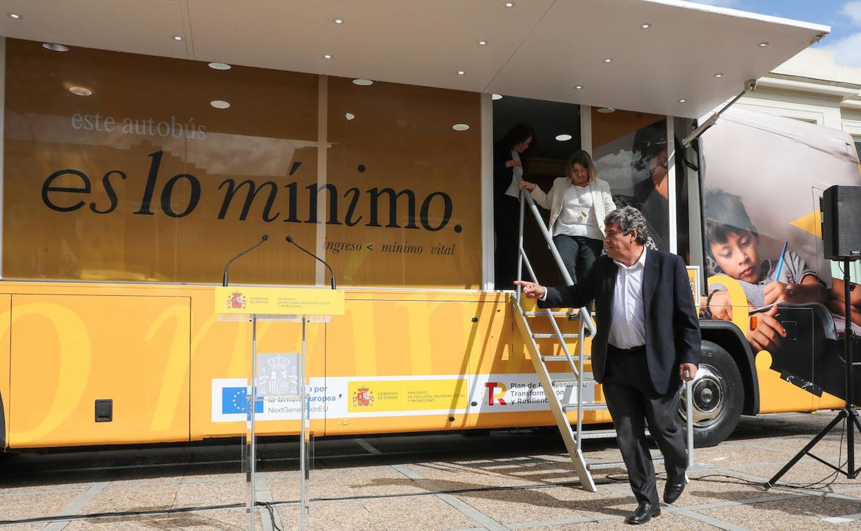 El ministro José Luis Escrivá junto al autobus informativo del Ingreso Mínimo Vital (IMV).