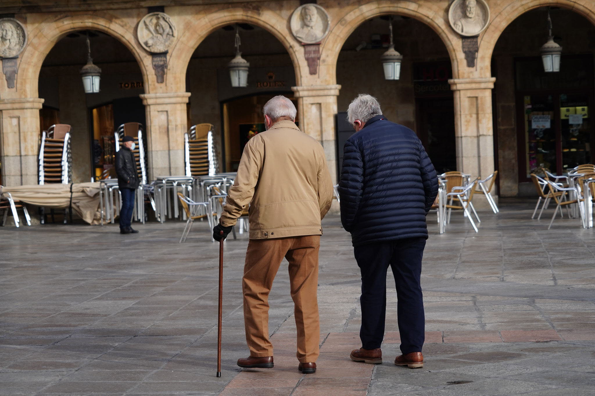 Dos hombres pasean por la Plaza Mayor de Salamanca. 