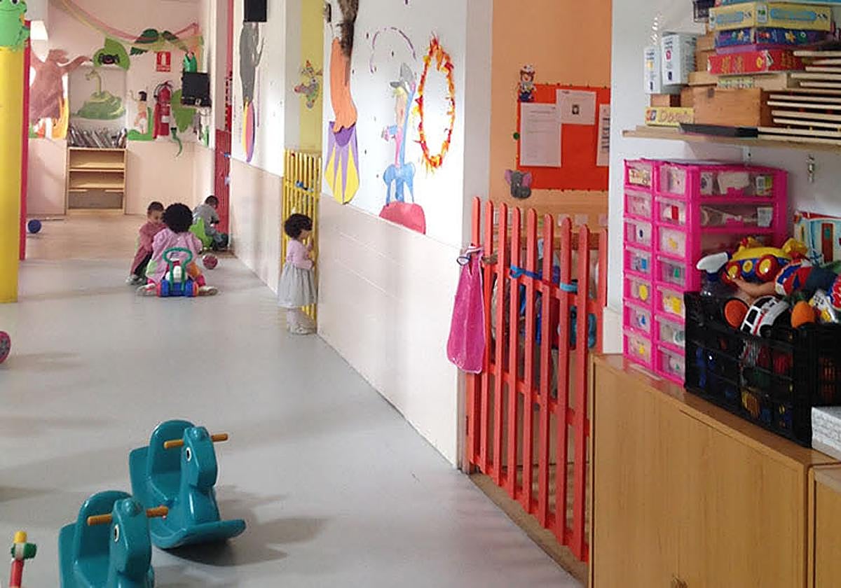 Al fondo, unos niños juegan en una escuela infantil de Salamanca.