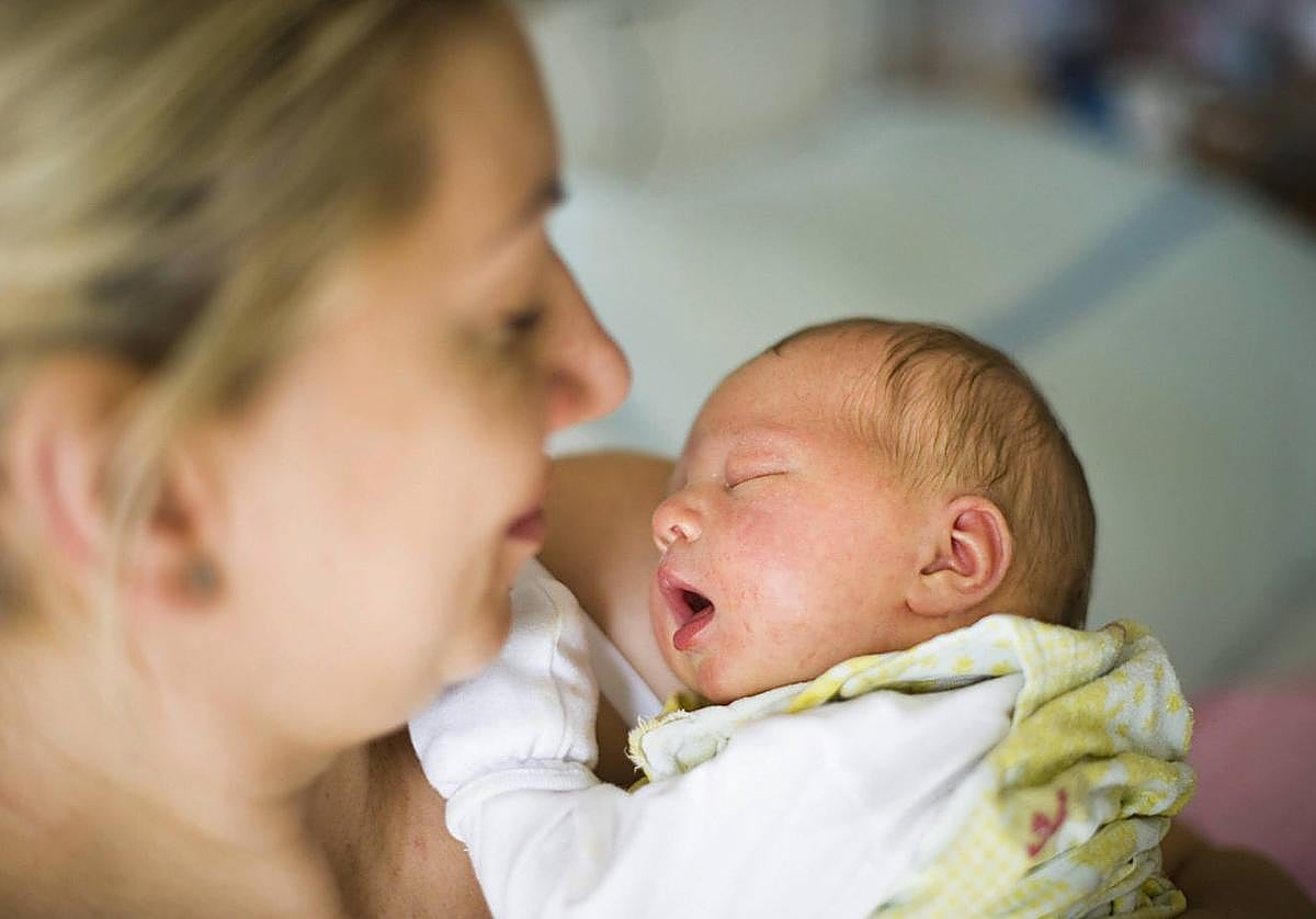 Una madre sostiene a su bebé recién nacido.