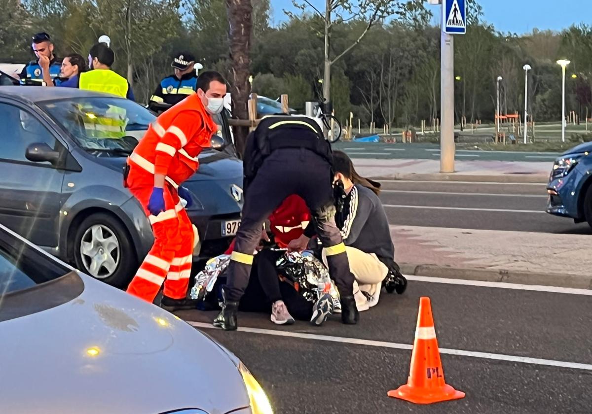 Los Servicios de Emergencias atienden a la joven tendida en el suelo.