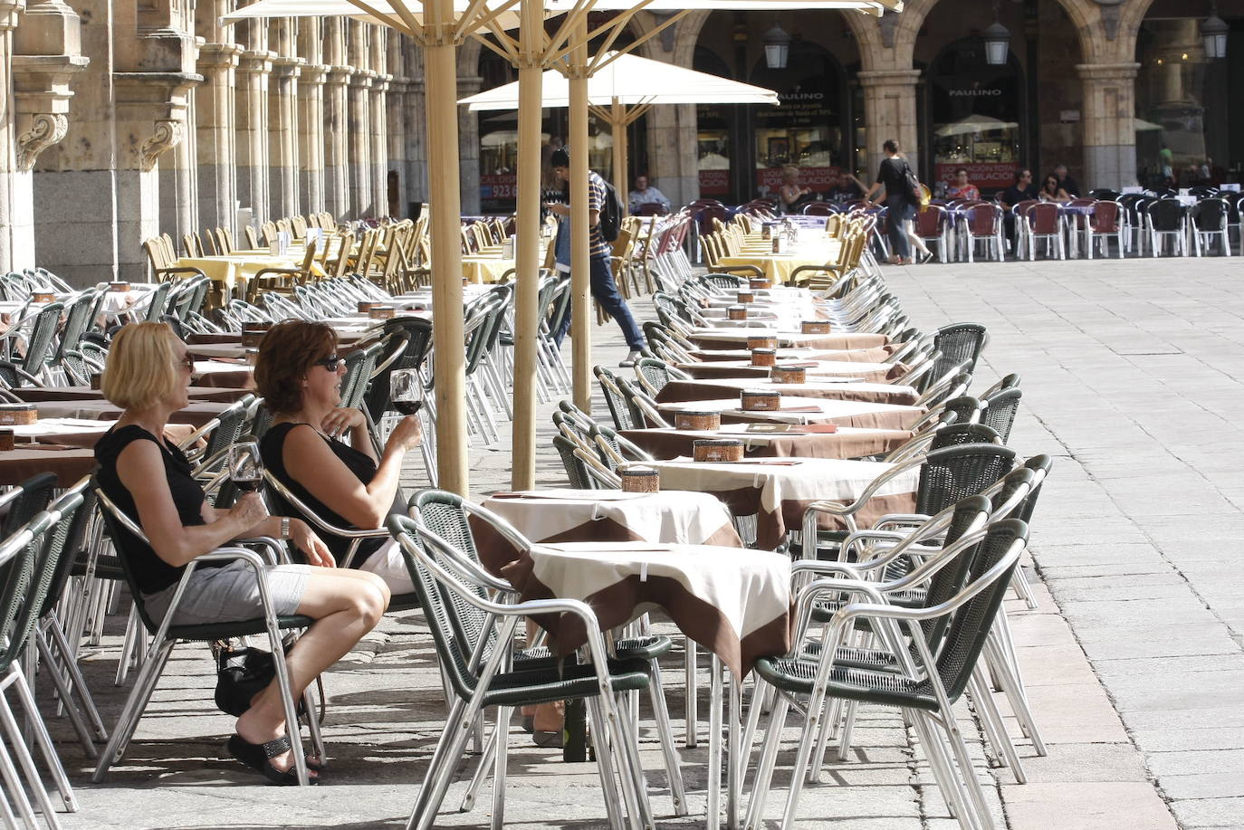 Turistas en una terraza de la Plaza Mayor de Salamanca en un día caluroso y soleado.