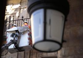 Dos operarios trabajan en la Plaza Mayor.