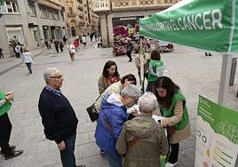 Varias personas firman en favor de la campaña de la Aecc.