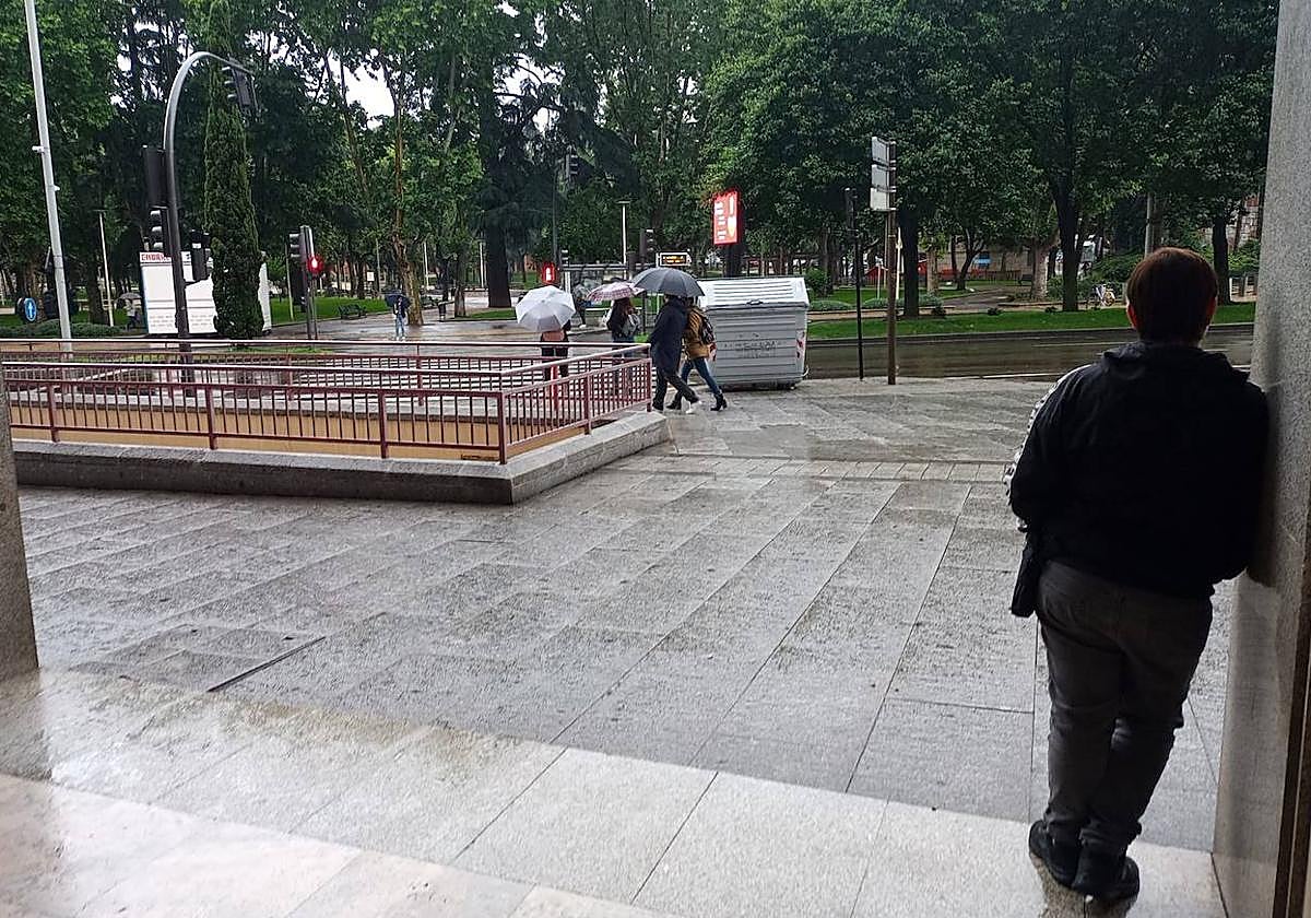 Una persona se resguarda de la lluvia en Salamanca.