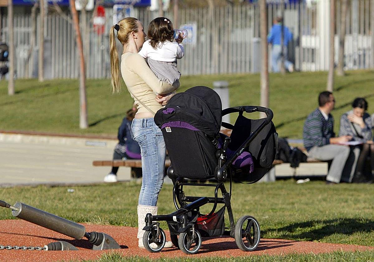 Imagen de archivo de una mujer con su hija en un parque.