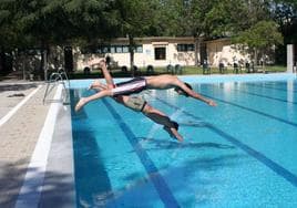 Dos jóvenes lanzándose de cabeza a una piscina.