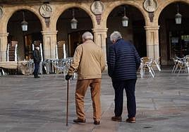 Dos personas mayores pasean por la Plaza Mayor de Salamanca.