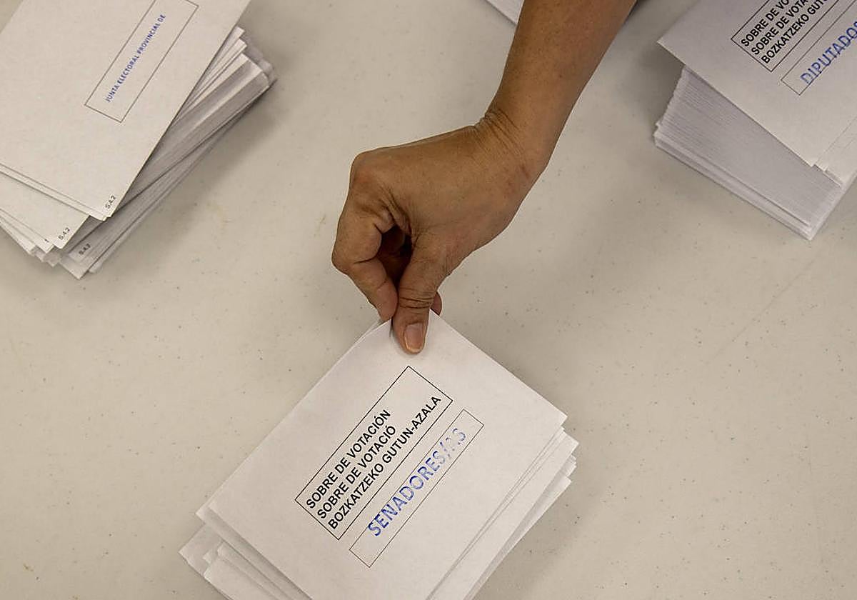 Una residente española toma un sobre de votación en el Consulado General de España de Santo Domingo en la República Dominicana para ejercer su derecho al voto en el 23J.