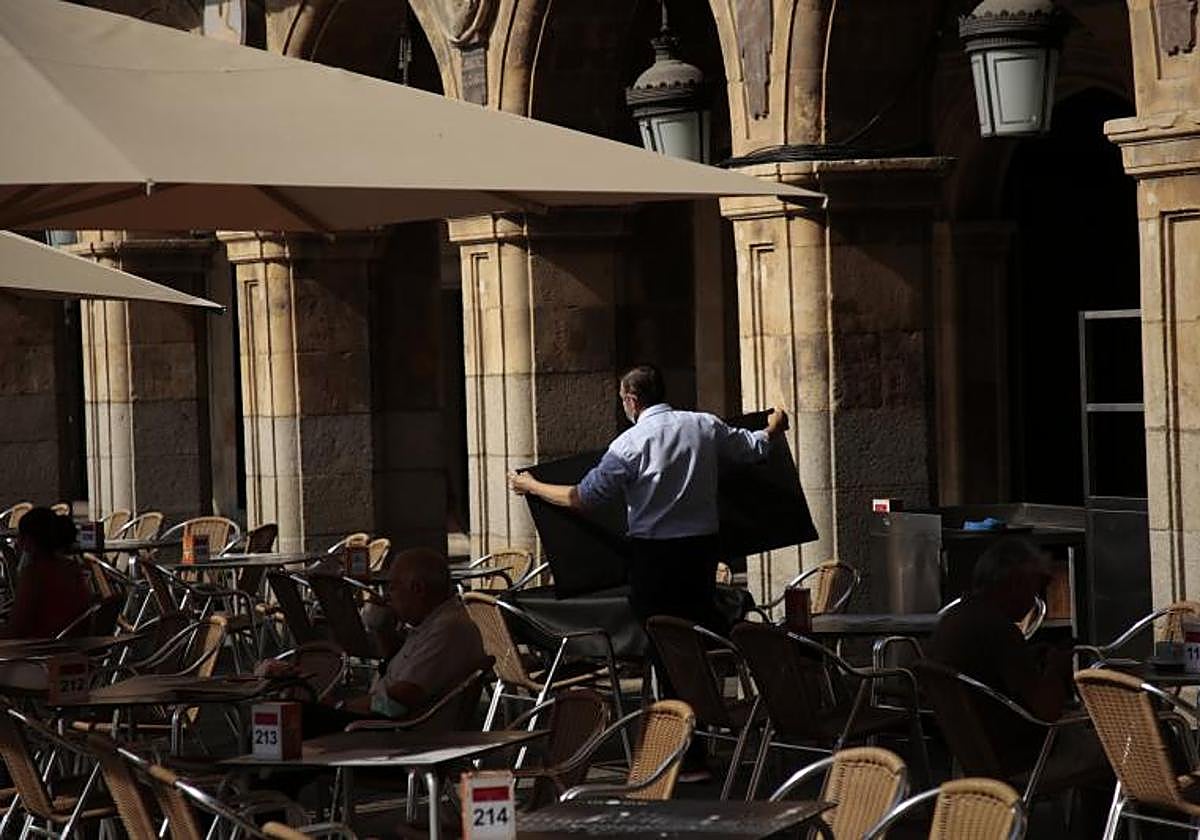 Un camarero recoge un mantel en una terraza de la Plaza Mayor de Salamanca.