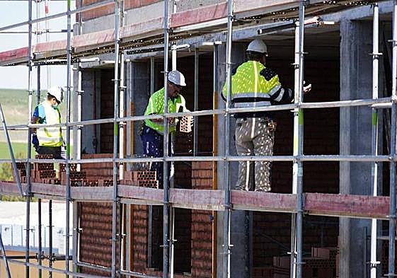 Obreros subidos en un andamio en la construcción de un edificio en Salamanca.
