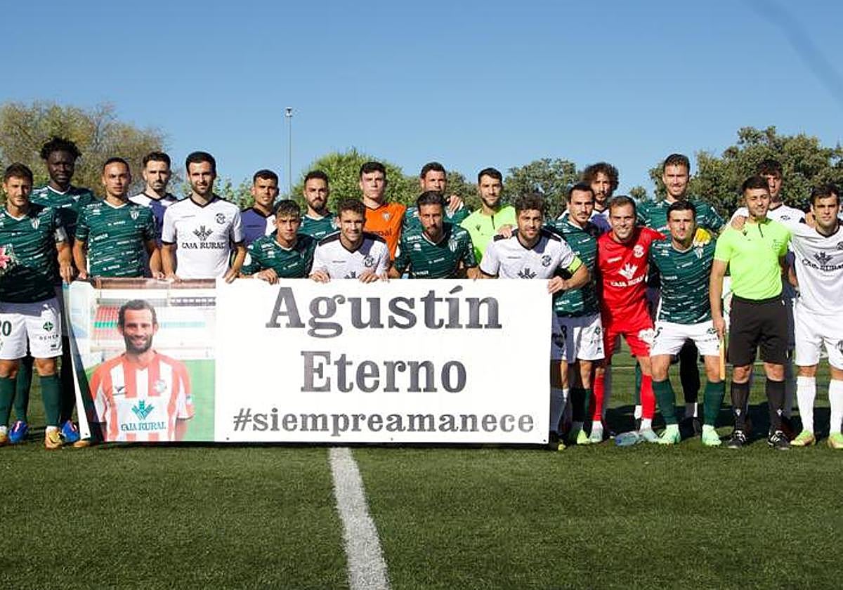 Los dos equipos posan con la pancarta de recuerdo a Agustín Villar.