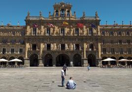 Un hombre, sentado en el suelo en plena Plaza Mayor de Salamanca.