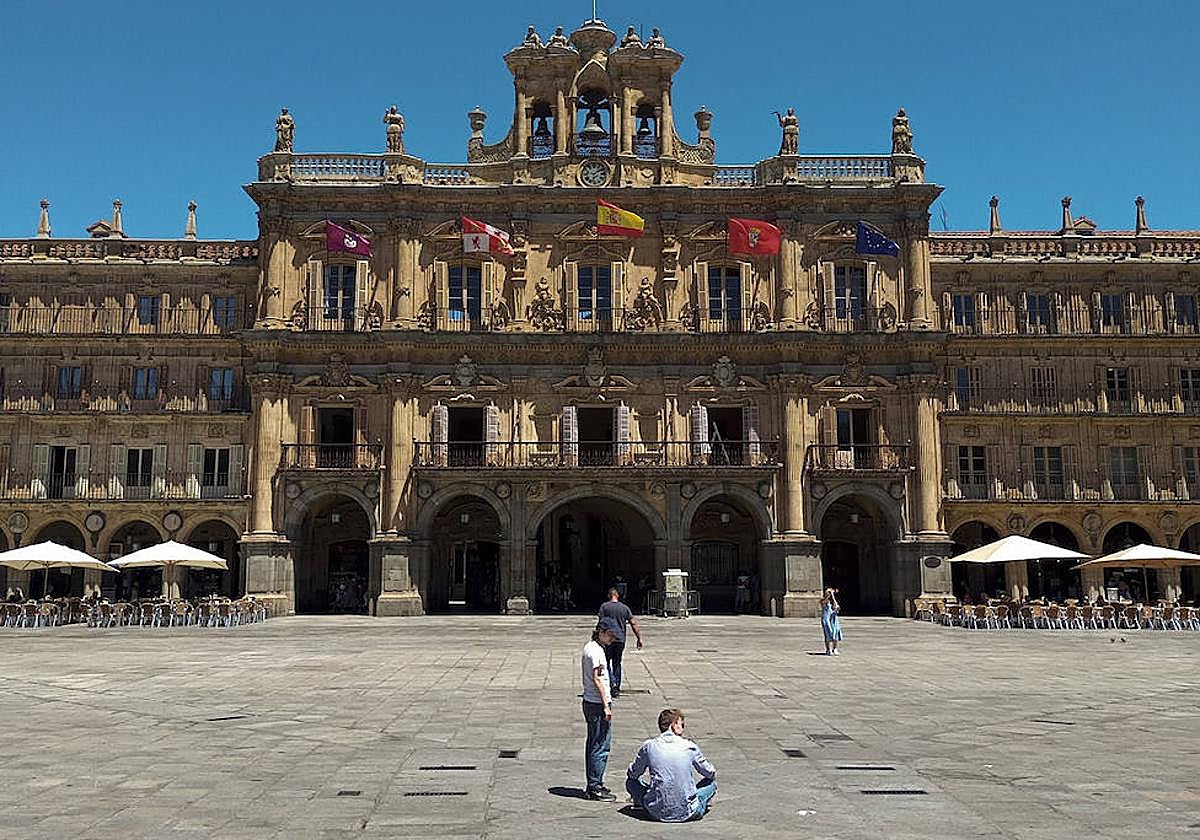 Un hombre, sentado en el suelo en plena Plaza Mayor de Salamanca.
