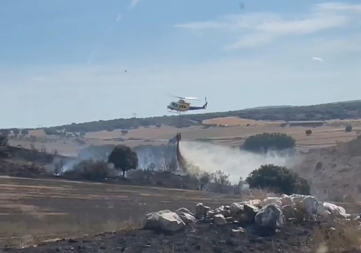 Un helicóptero vierte agua en la zona del fuego.