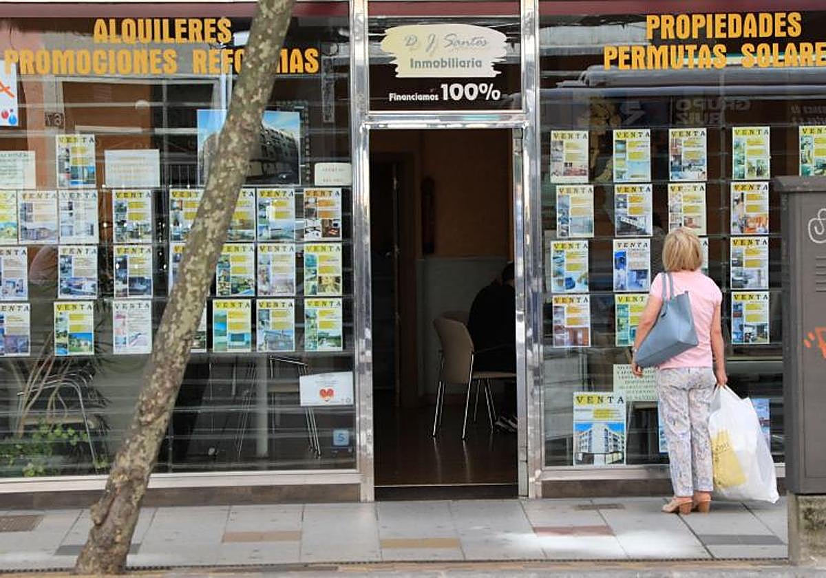 Una mujer observa anuncios de viviendas en una inmobiliaria de Salamanca.