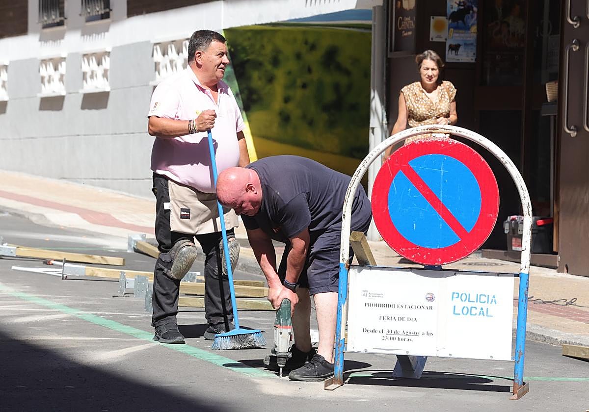 Una persona taladra el suelo para instalar los postes que delimiten la zona de terrazas.