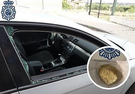 Imagen de uno los coches con la ventanilla rota y la piedra utilizada para ello.
