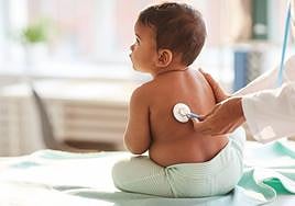 Bebé siendo examinado por un médico.